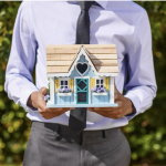 Realtor Holding a Miniature House