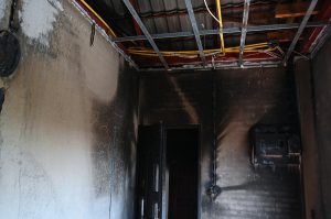 old scary interior burn house, cement wall and wood floor